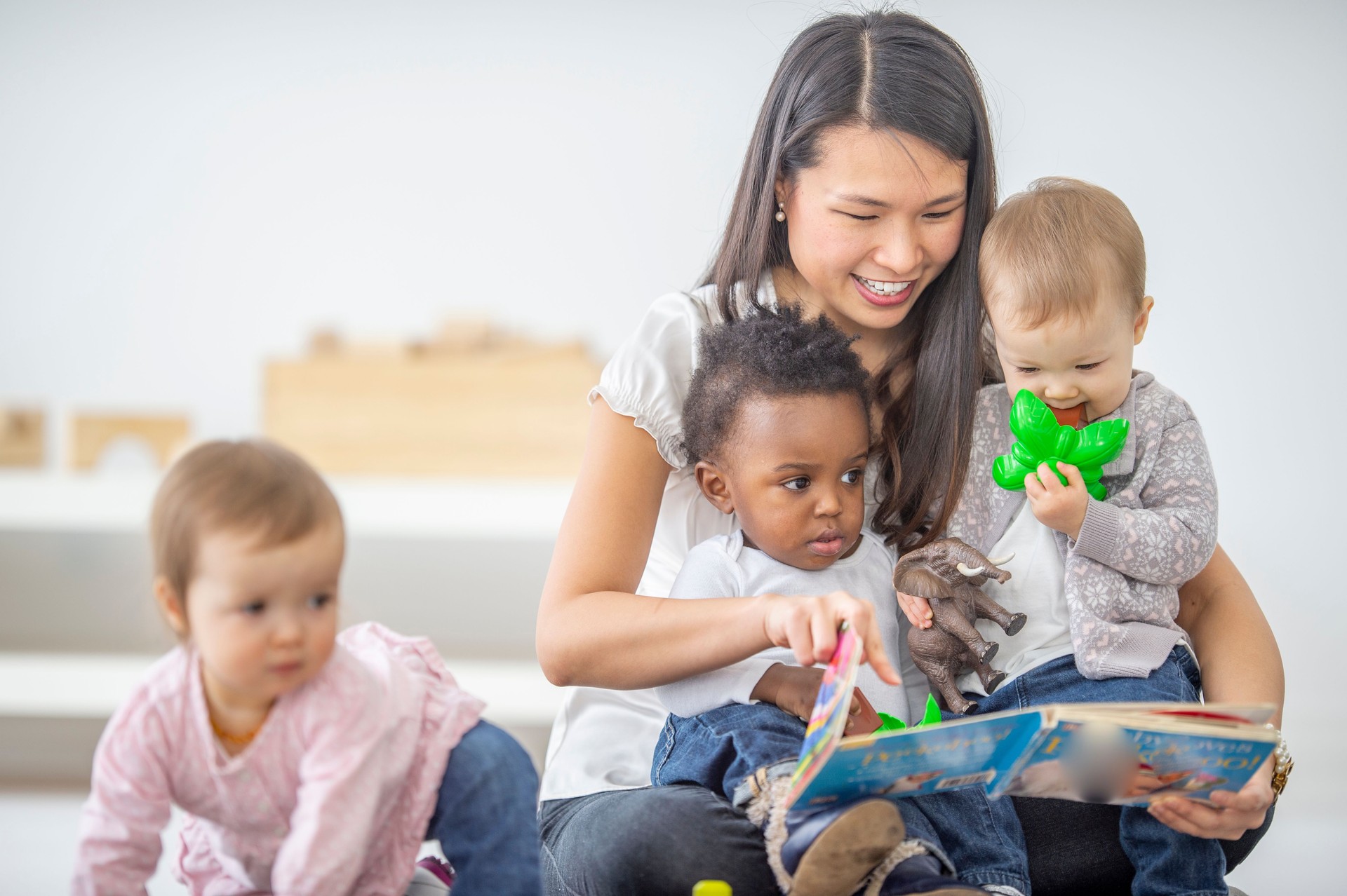 Preschool teacher reads a book to her students